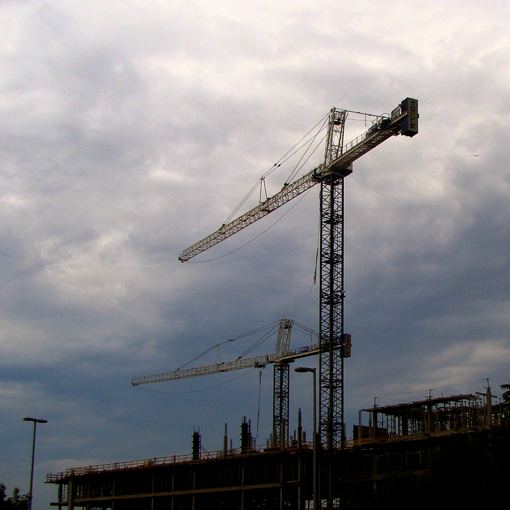 Cranes rising above a construction site.